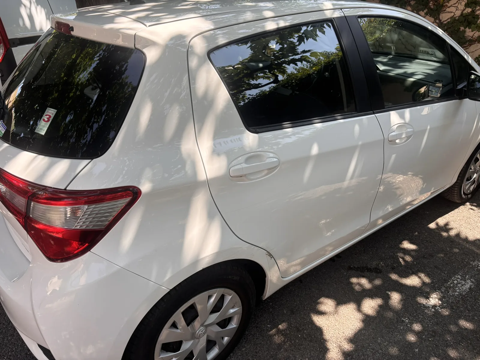 Toyota Yaris après nettoyage — profil arrière propre et brillant