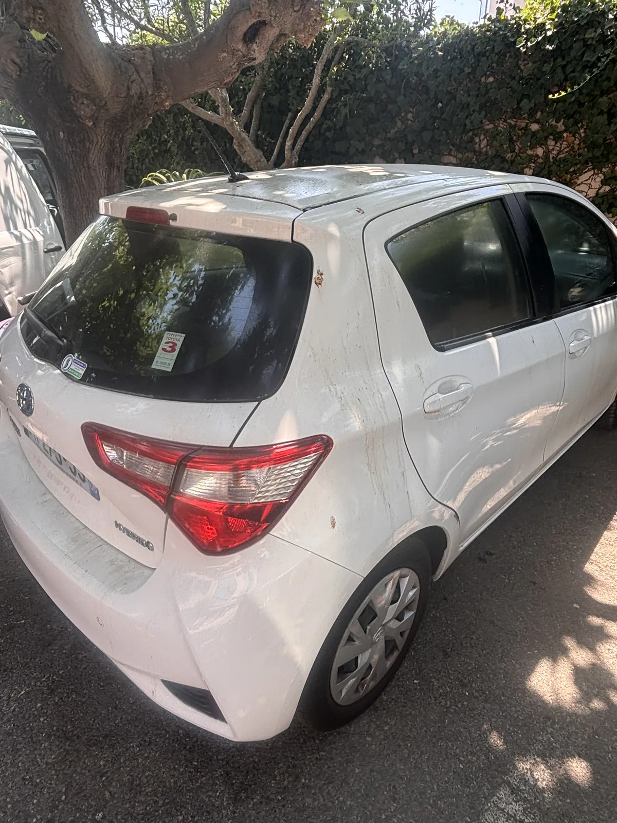 Toyota Yaris avant nettoyage — profil arrière terne et poussiéreux